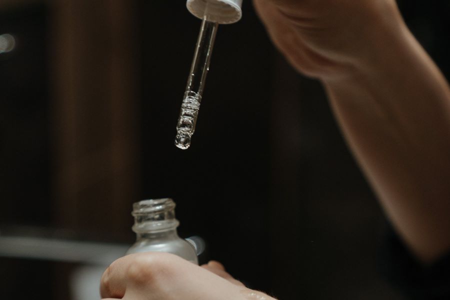 person holding a bottle of hyaluronic acid