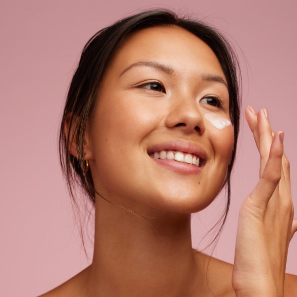 woman applying retinol on face