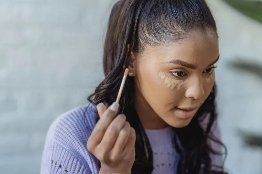 woman putting on concealer