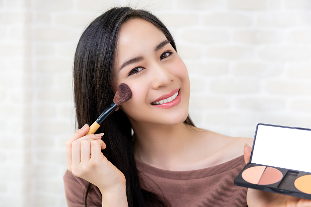 a woman putting in bronzer